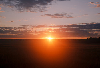 Fototapeta na wymiar Red sunrise flare upon the horizon