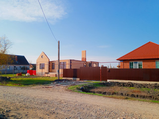 Fototapeta premium new house with an orange roof and a brown fence.
