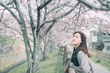 Under the cherry tree, the girl smiles gently