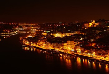 Fototapeta na wymiar Vista nocturna de la desembocadura del río Douro a su paso por las ciudades de Oporto y Vila Nova de Gaia en Portugal.