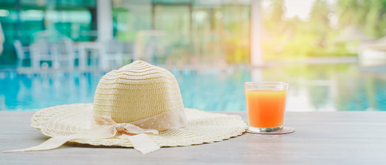 hat and orange juice near swimming pool ,panorama