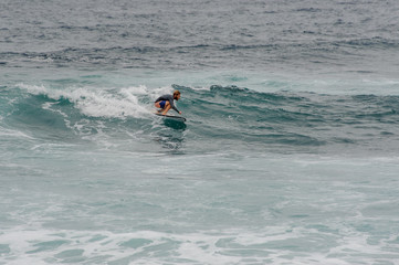 Man surfer glides on a surfboard on a wave