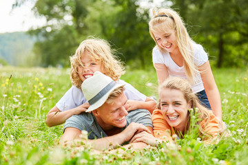 Familie und Kinder lachen im Gras