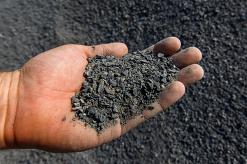 Close-up. Male hand holds a handful of natural ground stone