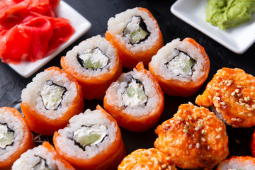 Philadelphia rolls with salmon cheese on a dark background, wasabi, ginger,