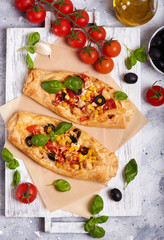 Delicious homemade filo pastry mini Pizza with chicken, tomatoes, black olives and cheese 