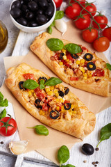 Delicious homemade filo pastry mini Pizza with chicken, tomatoes, black olives and cheese 