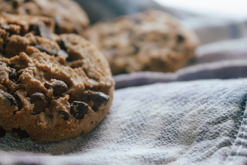 American chocolate cookies on blue cloth prepared for breakfast in the morning sunlight.