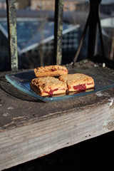 Cookies lie on a glass plate on an old cracked nightstand.