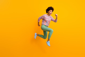 Fototapeta na wymiar Full size profile side photo of cheerful crazy funny afro american girl jump run fast hurry after black friday discount wear stylish green outfit isolated over shine bright color background