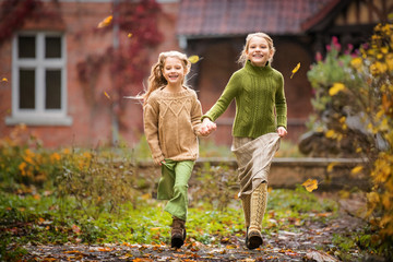 Two girls have fun running in the autumn park