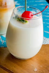 Frozen pina colado. Traditional classic Hawaiian or tiki bar tropical drinks. Drinks w/  dark aged rum, blanco tequila, amaretto, garnished w/ limes pineapple cherries coconuts served frozen.