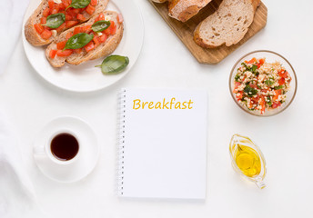 morning breakfast concept. on a white table lies a notebook with copy space, next to coffee, salad and vegan sandwiches