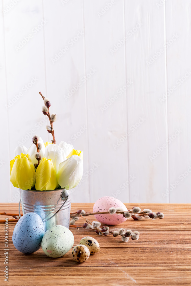 Sticker happy easter card with fresh spring tulips flowers in a bucket and handmade painted eggs on a wooden