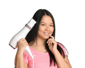 Beautiful Asian woman with hair dryer on white background