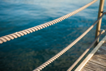 Close up of rope fence on wooden pier