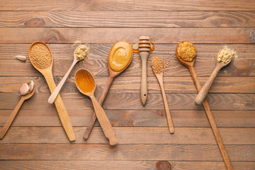 Tasty honey mustard sauce with ingredients on wooden background