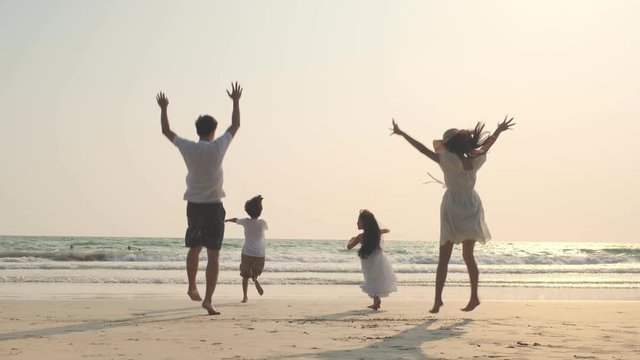 4k slow-motion Asian Family running and jumping together at beach with kids happy vacation travel beach concept