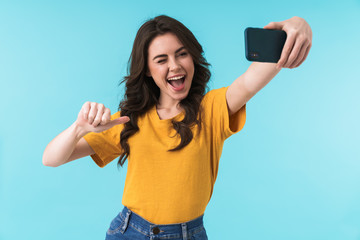 Fototapeta premium Optimistic young pretty woman take selfie by mobile phone.