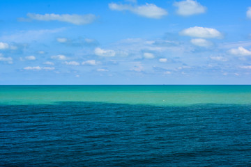 Obraz premium the sea surface is light turquoise and blue against a cloudy sky