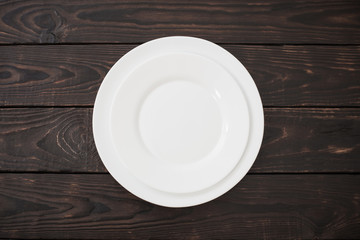 white ceramic plates on old dark wooden background