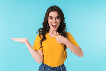 Positive young pretty woman pointing.