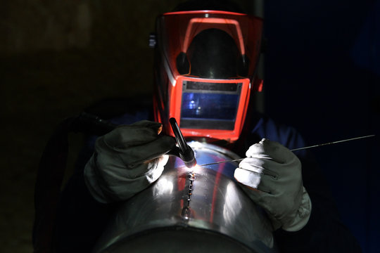 Man Doing Some Welding Of Exhaust Pipes