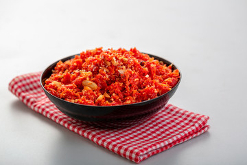 Gajar ka halwa is a sweet dessert pudding from India made from carrot, served in a bowl. Garnished with cashew, almond and pistachio nuts.