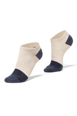 Subject shot of feet on tiptoe in white cotton socks with navy blue toes and heels. The photo is made on the white background.  