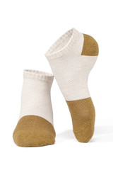 Subject shot of feet on tiptoe in white cotton socks with mustard-coloured toes and heels. The photo is made on the white background.  