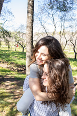 dos chicas disfrutando de una tarde primaveral en un parque lleno de almendros en flor