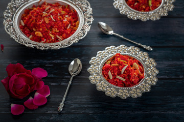  Gajar ka halwa is a sweet dessert pudding from India made from carrot, served in a bowl. Garnished with cashew, almond and pistachio nuts.