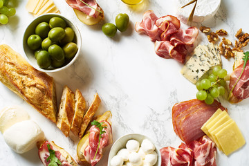 Big plate of appetizers for party of breakfast. Set of gourmet cheese and meat. Overhead view with copy space