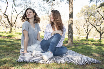 two young girls enjoying a spring day in an outdoor park surrounded by flowering trees