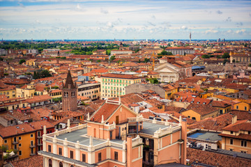 Fototapeta na wymiar View on roofs of most romantic city of Italy Verona, Veneto. Blue sky above red roofs of medieval city. Spring in italian city. City landscape of italian Verona. Travel tourism destination in Italy