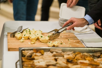 Man choosing delicious celebration finger food at table.