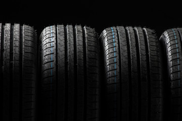Stack of brand new high performance car tires on clean high-key white studio background