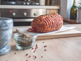 Raw turkey meatloaf on table. Uncooked spicy pork meat roulade prepared to roast, marinated with spices and herbs on a wooden plate.