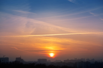 Dramatic colorful sunset or sunrise sky landscape with line row of city buildings silhouettes . Natural beautiful cityscape dawn background wallpaper. Metropolis city twilight time