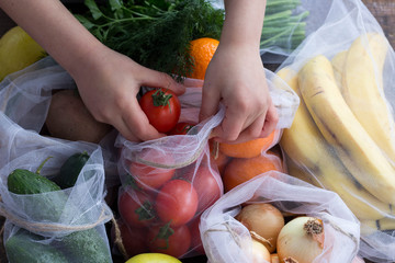Child hand hold plastic free recycled bags with fruit and vegetables Zero waste Protection and care for the environment
