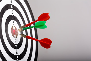 Close up shot green and red darts arrows in the target center. Business target or goal success and...