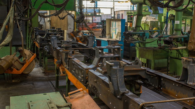 Conveyor assembly stage the body of tractor at factory timelapse