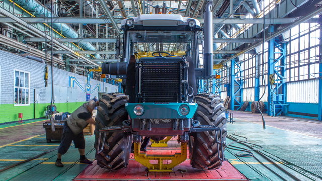 Conveyor assembly stage the body of tractor at factory timelapse