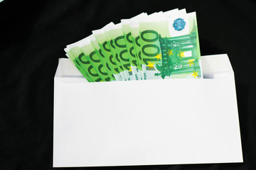 Money 100 euros in an envelope on an isolated black background