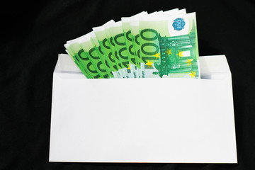 Money 100 euros in an envelope on an isolated black background