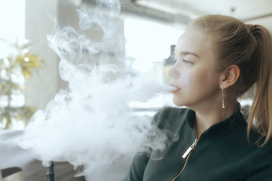 girl smokes a hookah at the bar / smoking, health, modern cigarettes vape