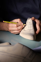 Italian shoes designer artisan, working on a wooden form