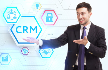 Business, Technology, Internet and network concept. Young businessman working on a virtual screen of the future and sees the inscription: CRM
