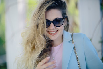 portrait of a european beautiful female model wearing sunglasses / girl outdoors walking, happy cheerful girl wearing glasses