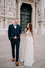 groom and bride posing in front of the church